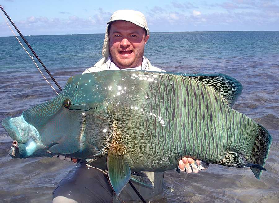 Илья Викторович Щербович с крупной рыбой-наполеон, пойманной нахлыстом, атолл Провиденс, Индийский океан